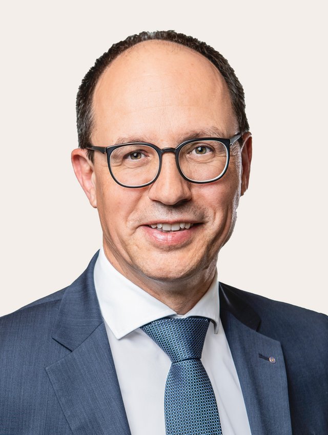 Marc Mächler Ein Foto von Marc Mächler vor beigem Hintergrund.