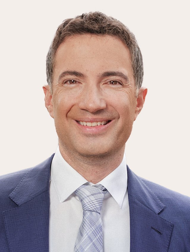 Prof. Dr. Andrea Caroni Ein Foto von Andrea Caroni vor beigem Hintergrund.