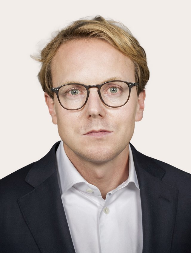 Benedict Neff Ein Foto von Benedict Neff vor beigem Hintergrund.